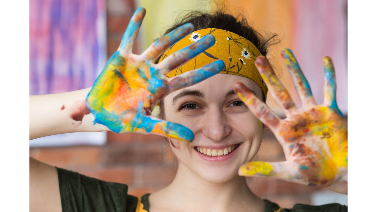 Young lady showing her hands covered in paint for course image art therapy for self healing